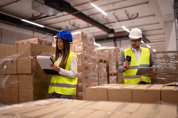 warehouse-workers-using-bar-code-scanner-and-tablet-and-checking-goods-inventory